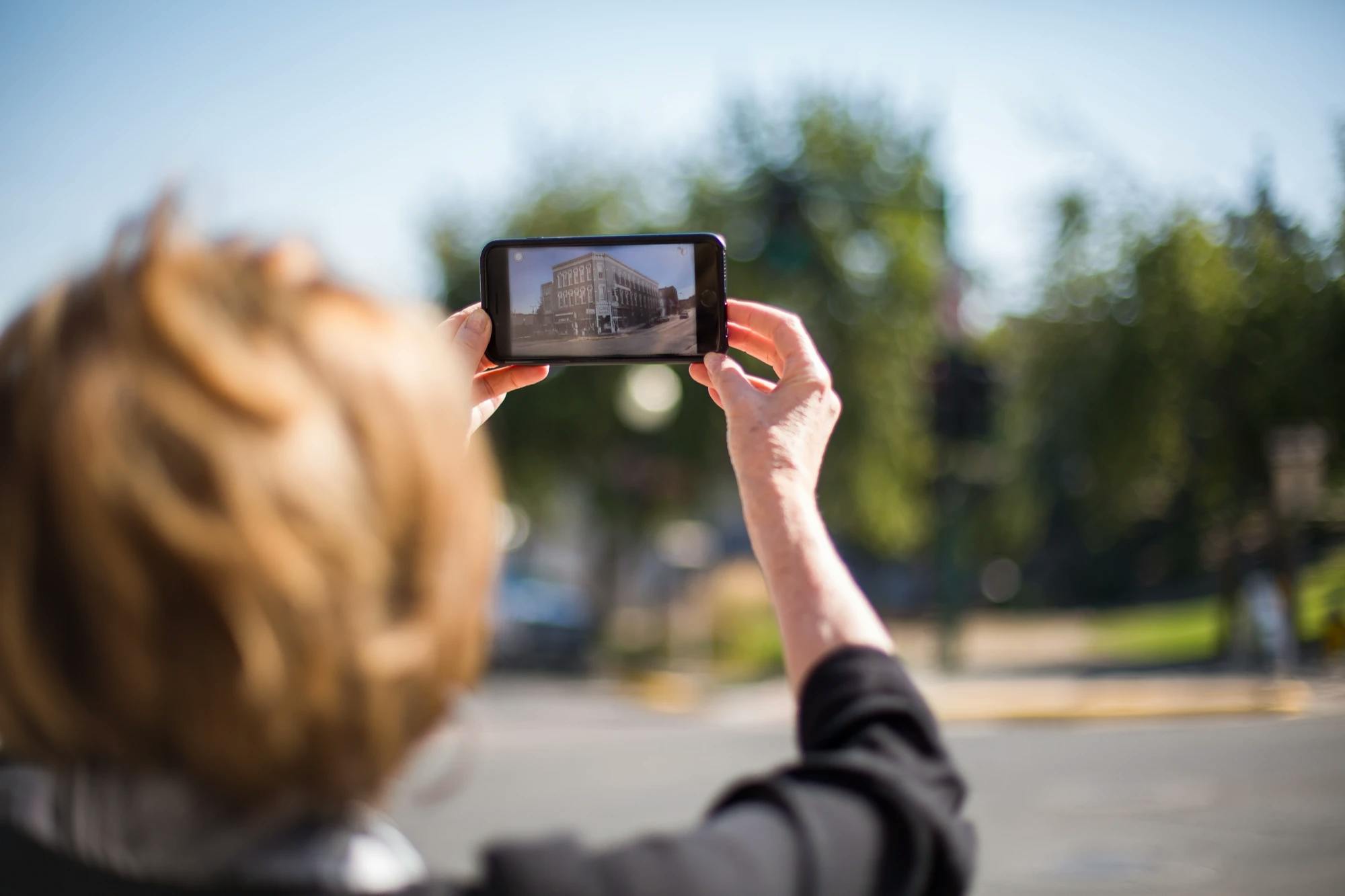 woman holding the helena walking tours augmented reality app