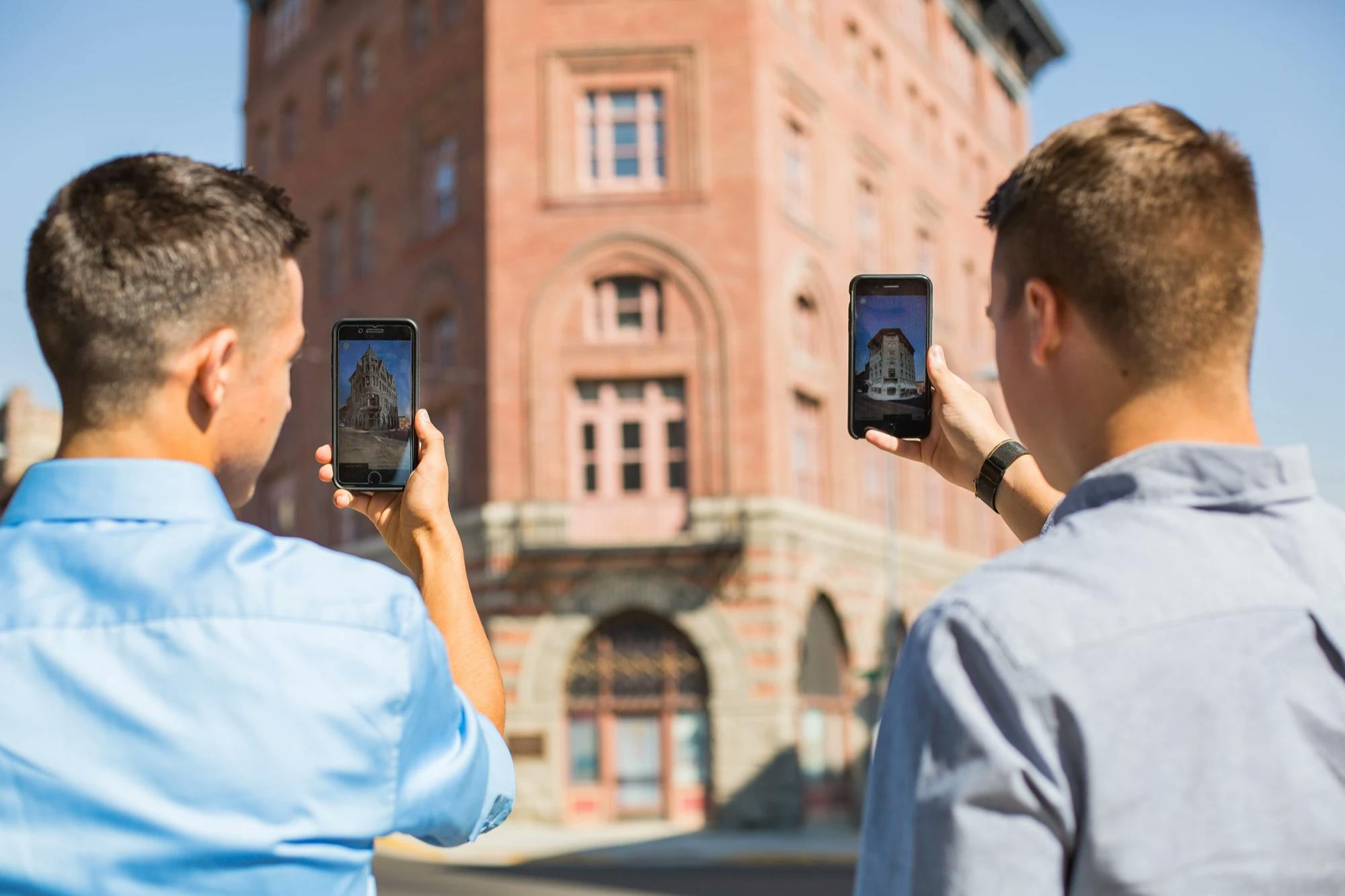 two men holding the helena walking tours augmented reality app